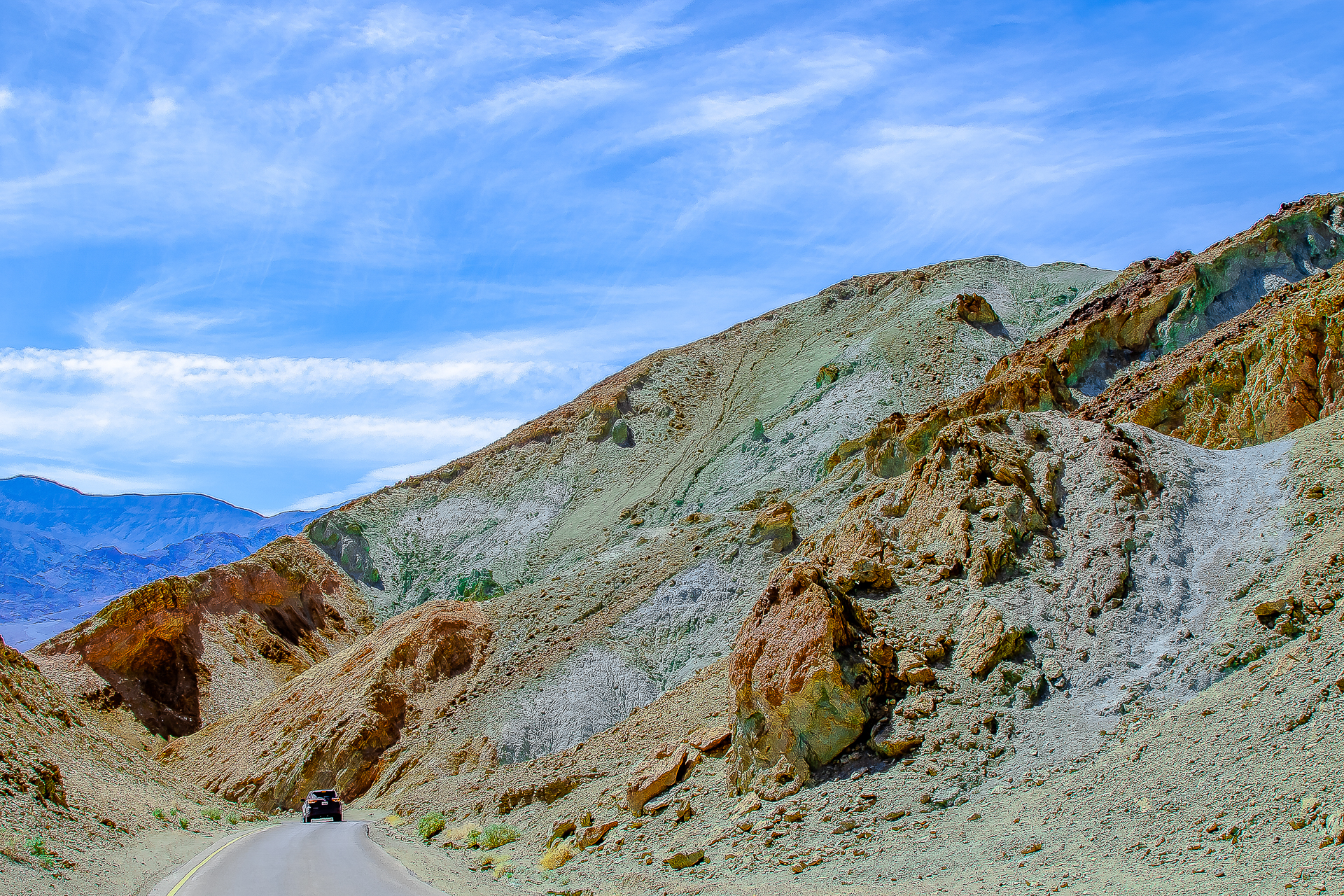 Artist's Drive — a car winds through hills stained green, pink, and red by mineral deposits